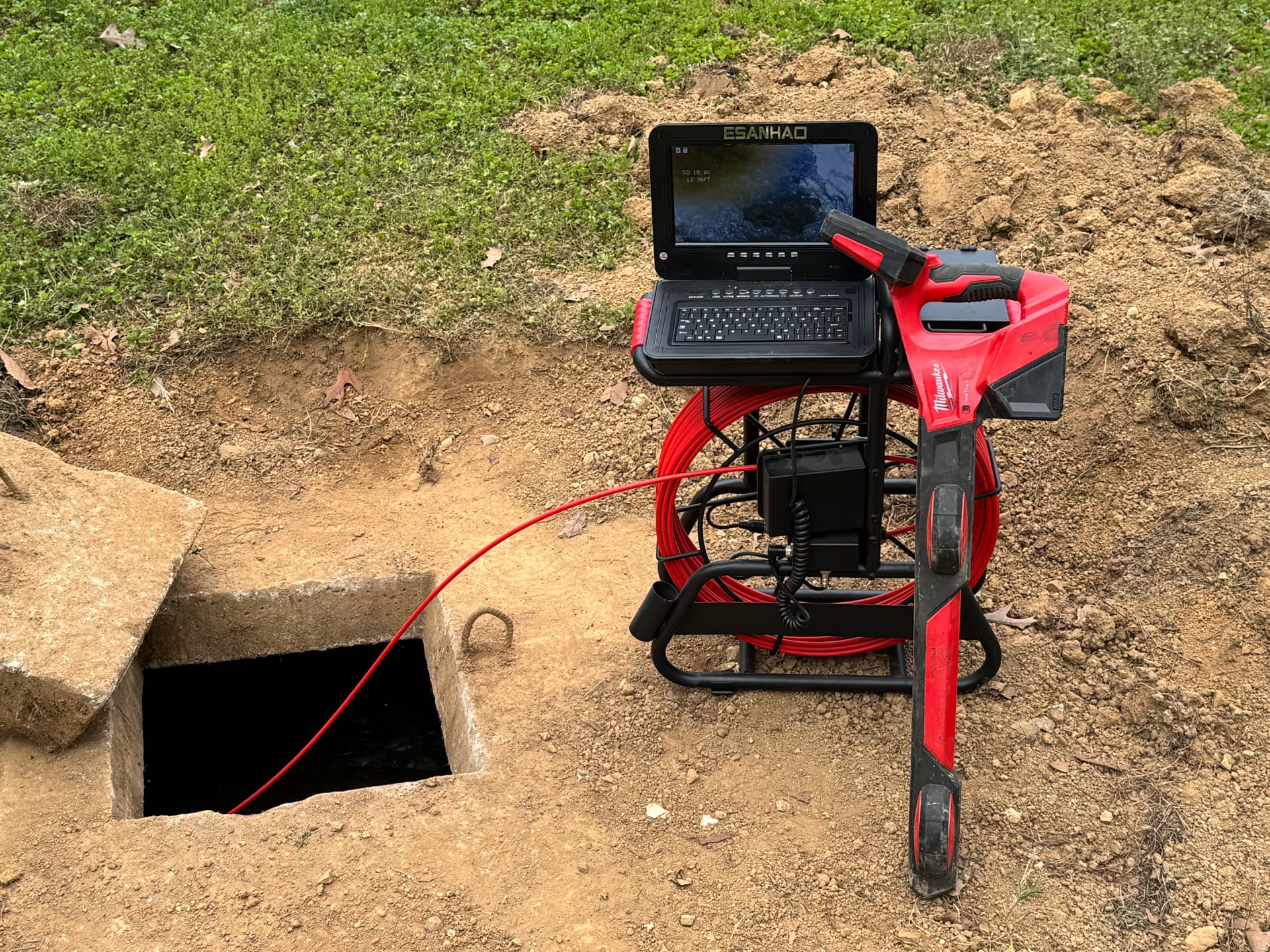 Sewer camera inspection equipment set up at an open septic tank lid in Etowah County, Alabama